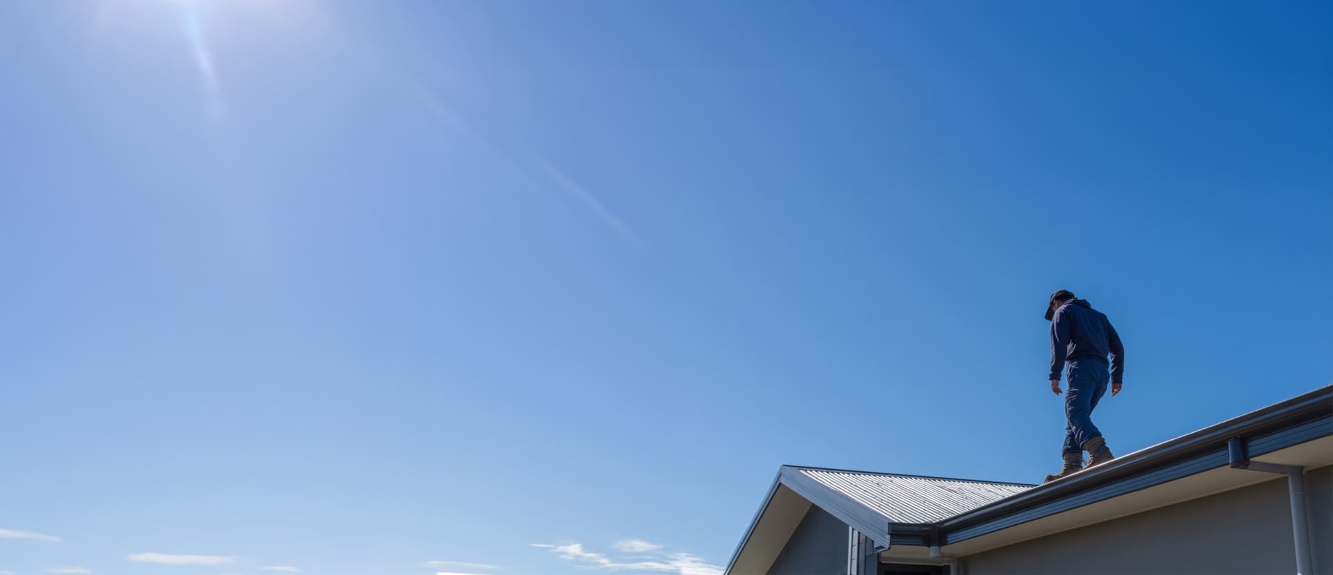Roofer working on a New Zealand home at golden hour